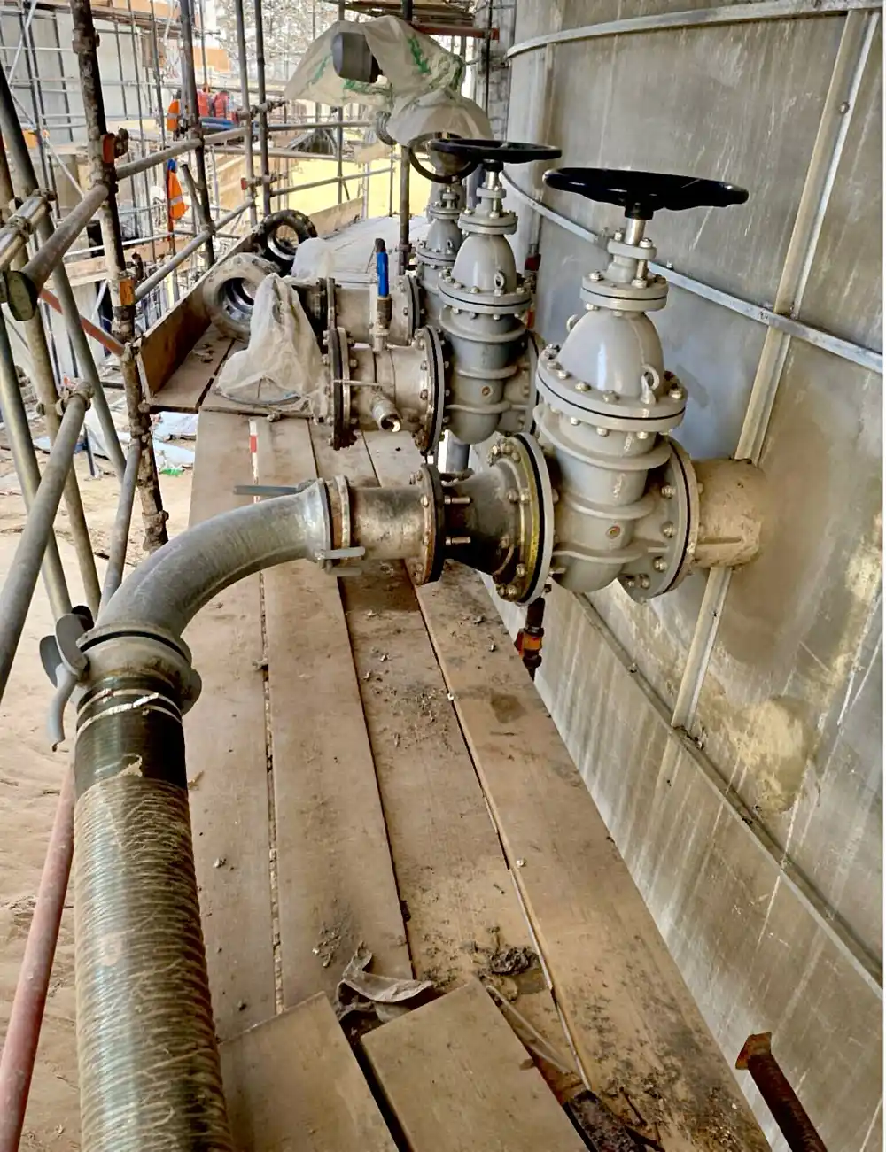 etailed view of the elevated tank connection point featuring grey valves and custom fittings used to connect the hose line to the PN10 inlet.