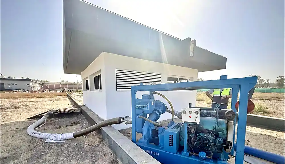 An industrial pump, with suction hoses routed down into a concrete trench to overcome excavation access challenges.