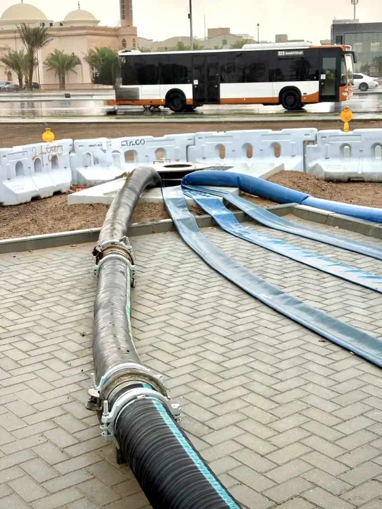 Rubber and lay-flat hose routing across the site to the discharge manhole.